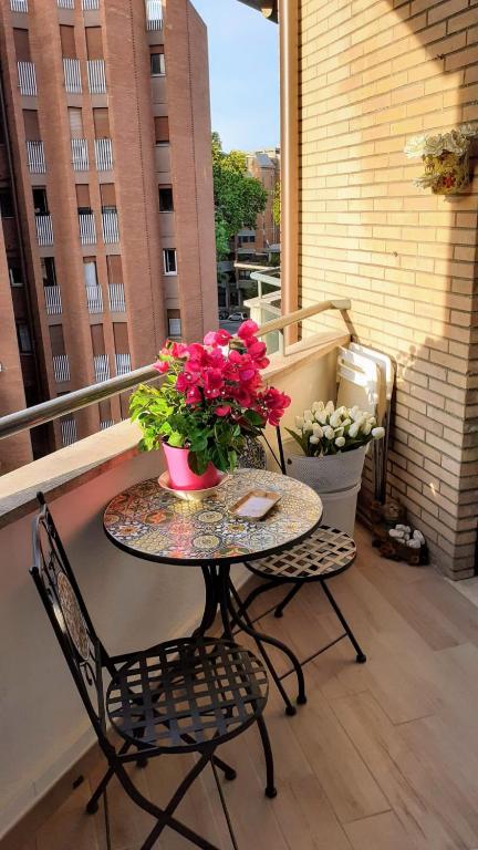 Balcony/terrace with flowers, table, chairs, Rome cityscape