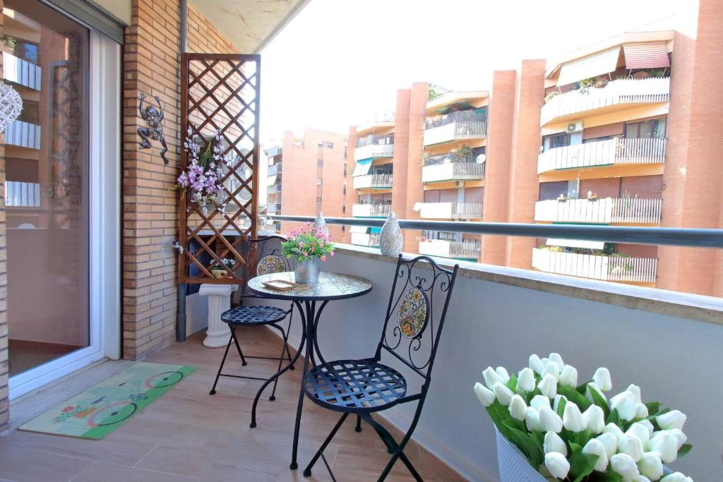 Balcony/terrace with table, chairs, flowers, and Rome view