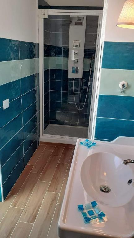 Bathroom with teal and light green tiles, white fixtures