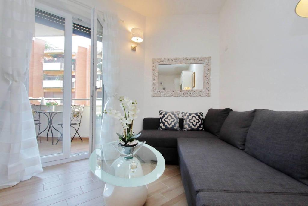 Living room with dark sofa, decorative mirror, wooden floor